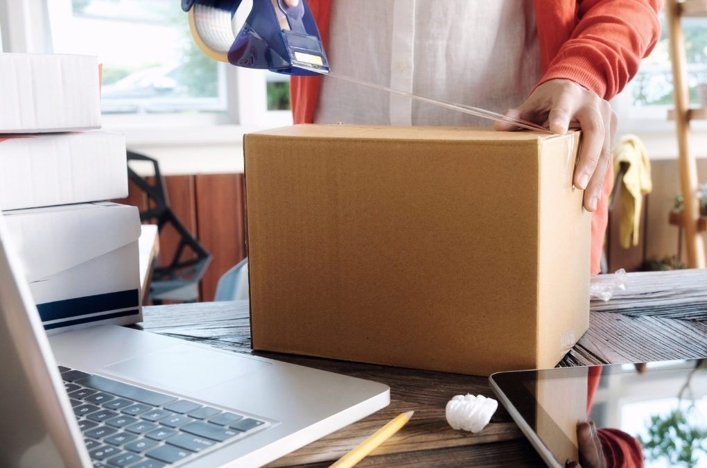 Close up business owner packing a box to ship out
