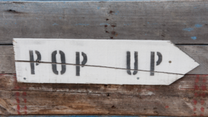 Wood sign points to Pop Up shop
